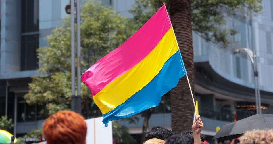 Flaga osób panseksualnych powiewająca nad tłumem